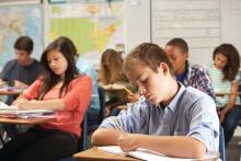 Students writing in a classroom.